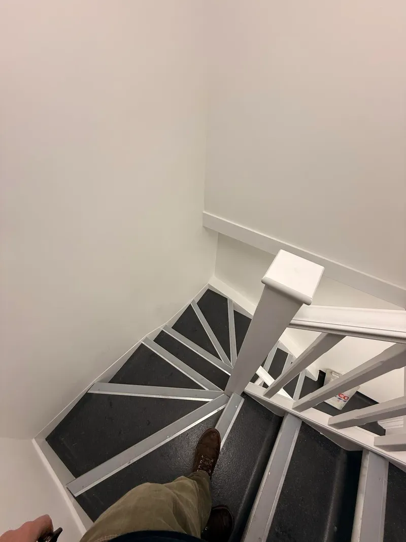 The new staircase with white balustrades, looking down to the lower floor.