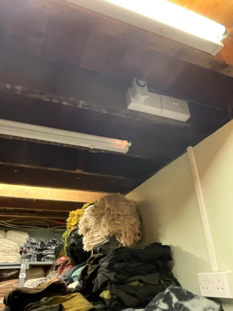 The old basement, its ceiling at head height, packed with the shop's stock