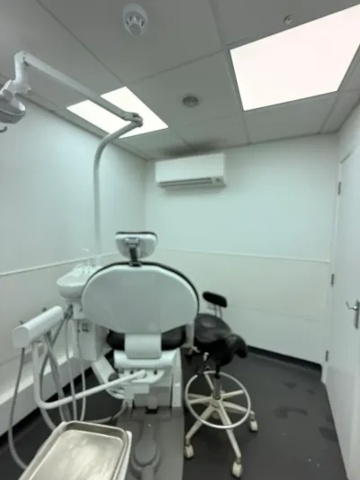 A completed dental treatment room with a new chair, overhead light and clinical wall and ceiling finishes.