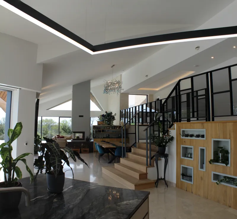 Inside Weald House: the living space, with the stair and a glazed gallery above.